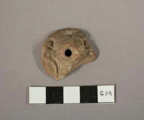 Pottery spindle whorl in form of animal head with open mouth