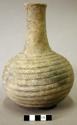 Ceramic vessel, long and flared neck, ridges around body, flattened base.