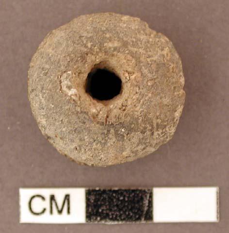 Spindle whorl. pulley-shaped. discoidal, thin, single perforation in center, som