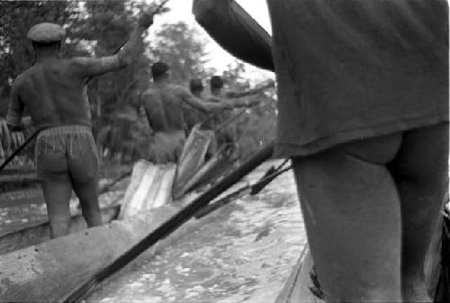 Men paddling canoes