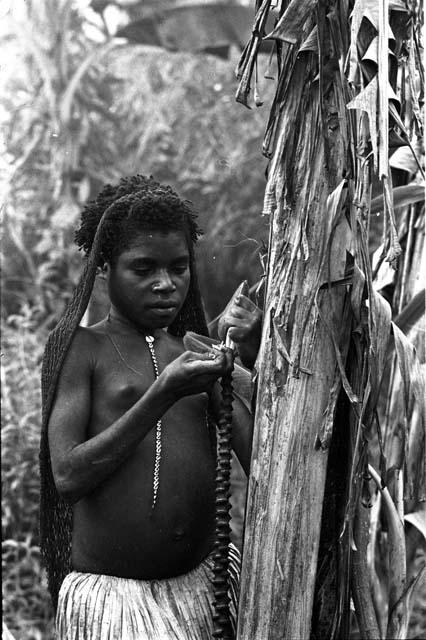 Portrait of Werekma holding the fruit of a banana bunch