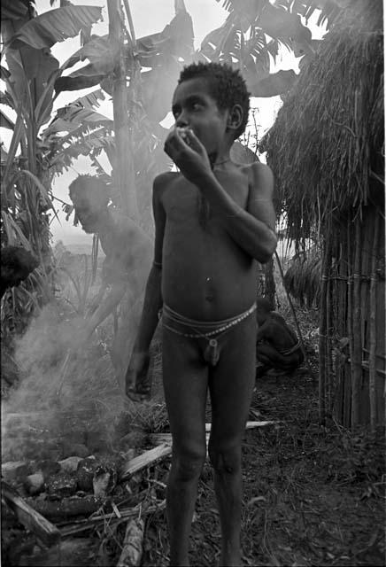 Uwar eating something, Yoli and Yegé Asuk are working behind him