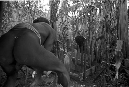 Yegé Asuk working on the waroleget with a stone axe