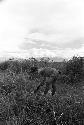 Woman washing hiperi in the fields; she has clay on her