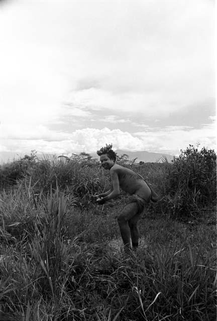 Woman washing hiperi in the fields; she has clay on her