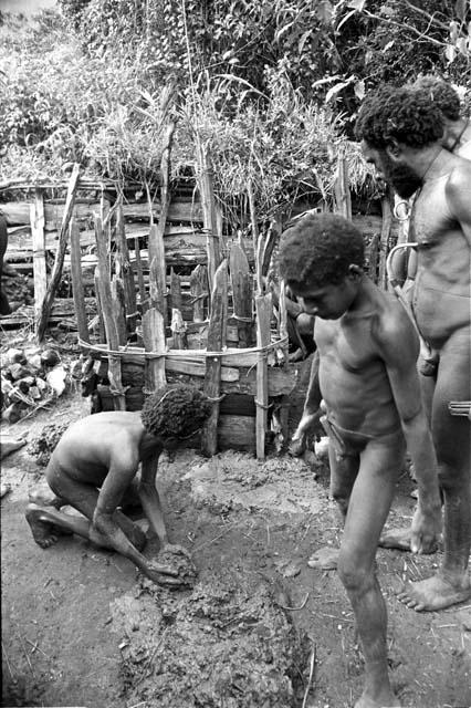 Children using mud to plaster around the edges of the waroleget