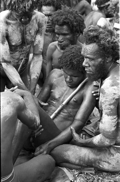 Yonokma being held while he is prepared for his funeral