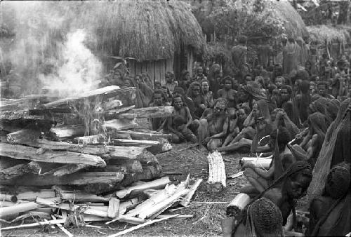 Women mourning around the burning funeral pyre