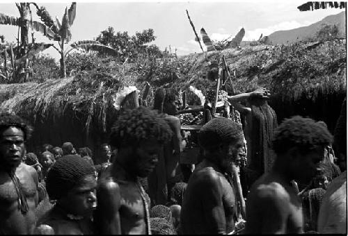 Men mourn, over their heads the women are visible at the pia