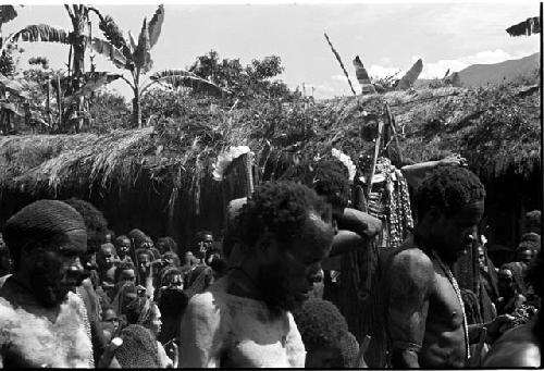 Men mourn, over their heads the women are visible at the pia