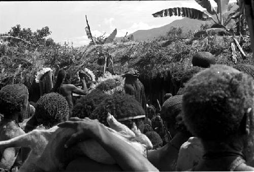 Shot over the heads of the men as they mourn towards the pia