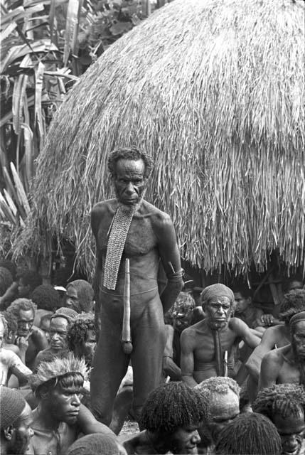 Yohonoroik watching procedures at Yonokma's funeral, Aloro in front of him