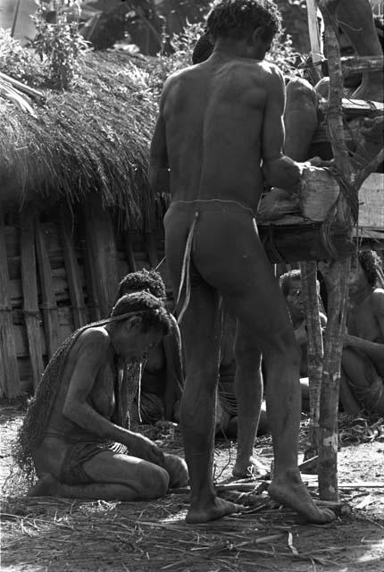 Men arranging Yonokma's corpse on the pia in the early parts of the funeral ceremony