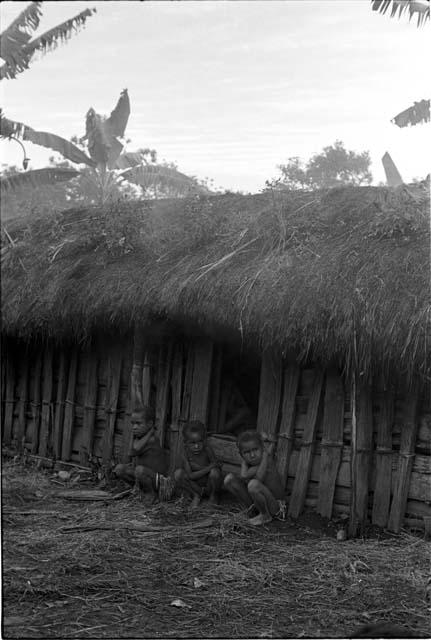 Three little girls sit by the hunu in Abulupak in the early morning