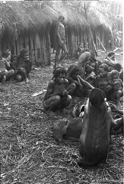 Large group of women sit outside the hunu