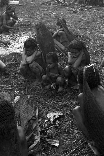 Women crouched, keeping themselves warm near the fire