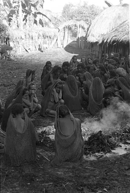 Women seated around the dead fire from Yonokma's funeral and the sus which was to be distributed that day