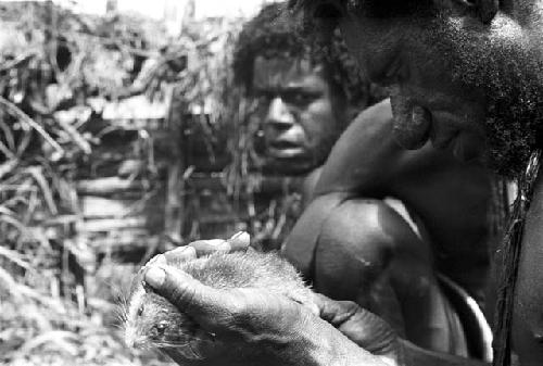 A man inspects a mouse in his hands