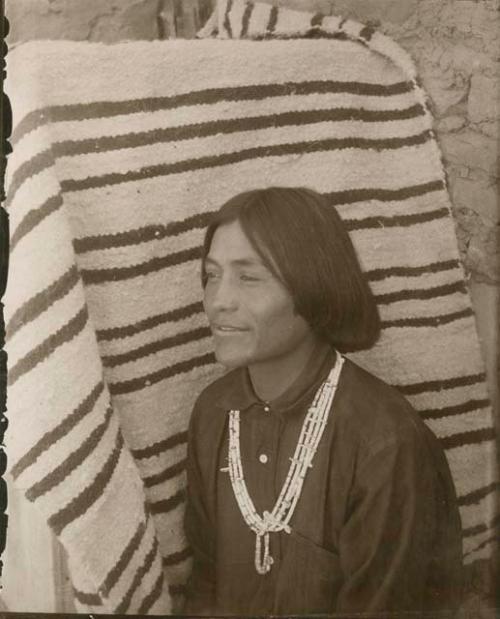 Navajo man standing in front of blanket