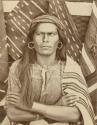 Navajo man sitting in front of blankets