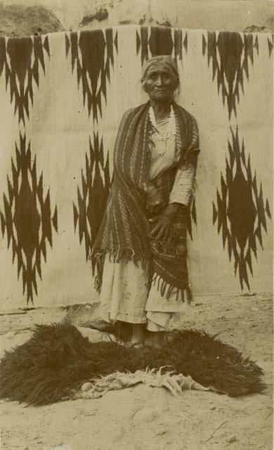 Navajo woman standing in front of a blanket
