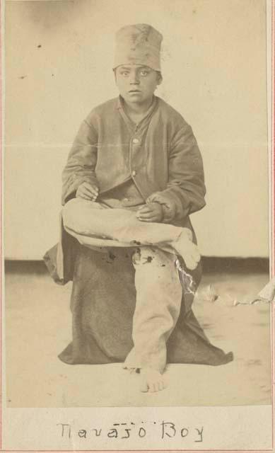 Navajo boy, seated and wearing cap