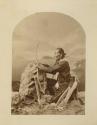 Navajo man in a studio-staged scene aiming a bow and arrow