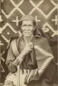 An old Navajo photographed with a blanket over his shoulders