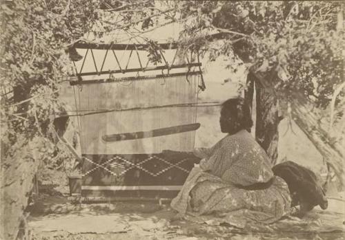 Navajo woman weaving with a blanket loom