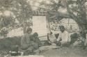 Navajo family sitting next to a blanket loom