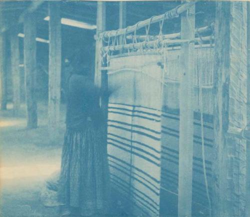 Navajo woman weaving on a loom