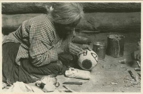 Navajo woman painting the side of a bowl