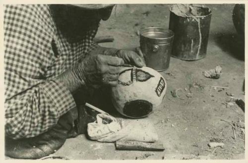 Navajo woman painting the side of a bowl