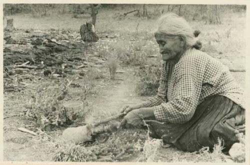 Navajo woman applying gum to the inside of a cooking pot after firing