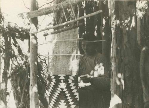 Navajo woman weaving on a loom