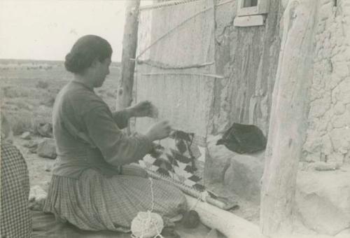 Navajo woman weaving on a loom