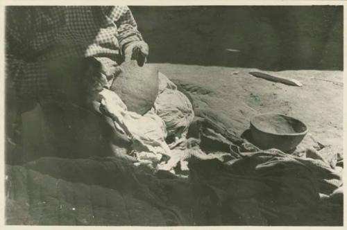 Navajo woman scraping a pot with a corncob