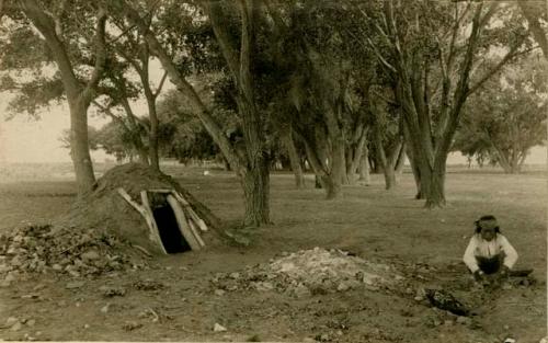 Sweat House and a Navajo Man seated on the ground