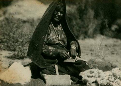 Woman placing wool on wool cards