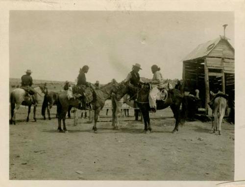 Group of Navajo men gathered on horseback