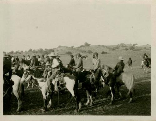 Navajo people on horseback watching races