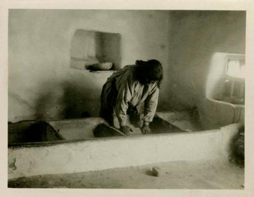 Meal bins and woman at Acoma