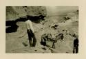 Man with donkey, or mule, climbing down rocks at Acoma