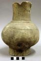 Ceramic complete vessel, mended, incised around body, platform base