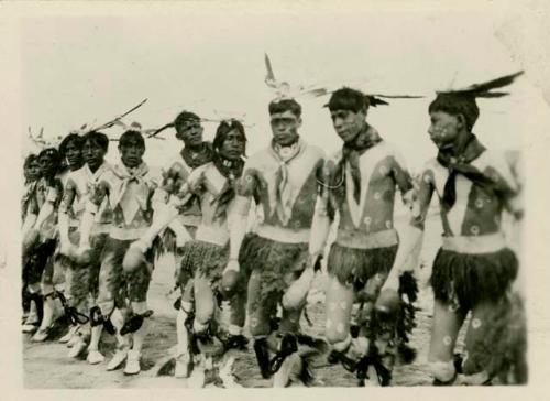 Men dancing in line. One in series of six depicting Buffalo dance