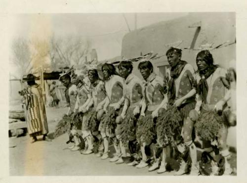 Men dancing in line. One in series of six depicting Buffalo dance