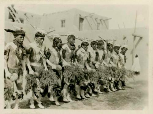 Men dancing in line. One in series of six depicting Buffalo dance