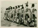 Men dancing in line. One in series of six depicting Buffalo dance