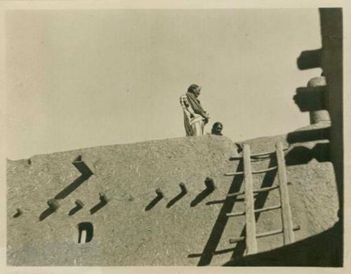 Headmen crying greetings and orders to the people from the top of the north Pueblo.