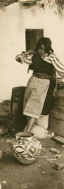 Young woman of Isleta with large olla sitting on ground before her